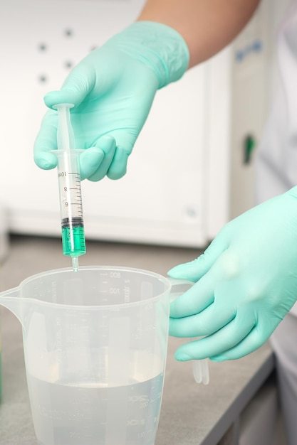 The beautician uses a syringe to add disinfectant to the water sterilization of tools