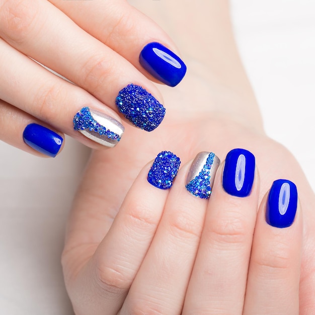 Photo beautifil blue manicure with rhinestone. nail design. close-up.