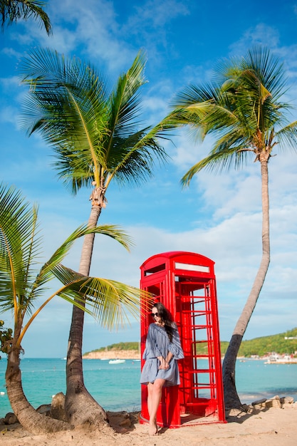 Donna di beautiftul vicino alla cabina telefonica rossa nella baia antigua di dickenson.