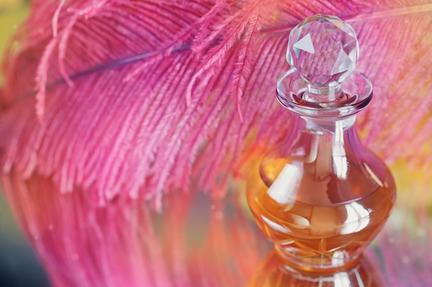 Beautiful abstract blurred soft background with purple feather and bottle of perfumed or aromatic oil