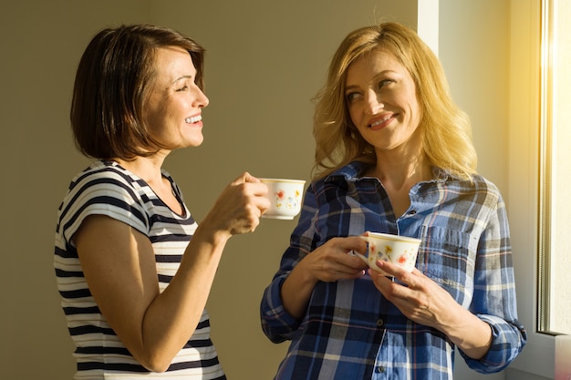 Photo beautiful adult woman holding hot cups of coffee drinking