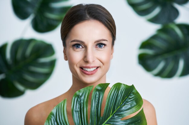 beautiful adult woman posing against leaf background