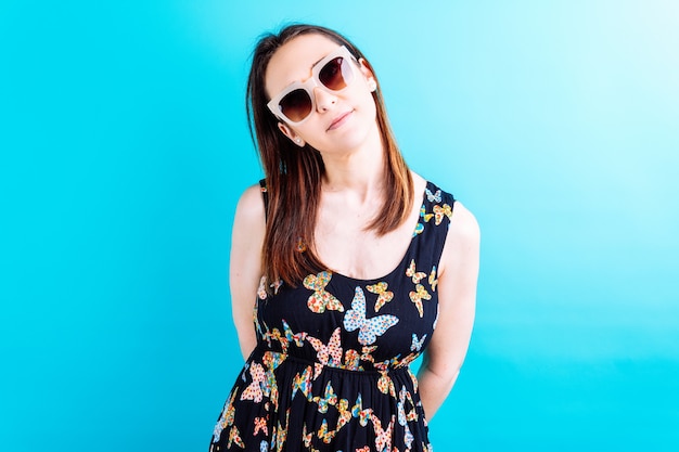 Beautiful adult young woman in yellow jacket wearing sunglasses looking straight ahead. summer fashion concept. arrival of summer and good weather