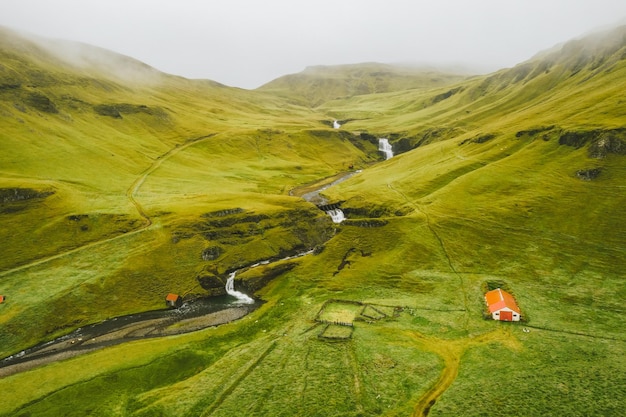 Beautiful aerial drone view of Icelandic landscape with green fields and river in summertime