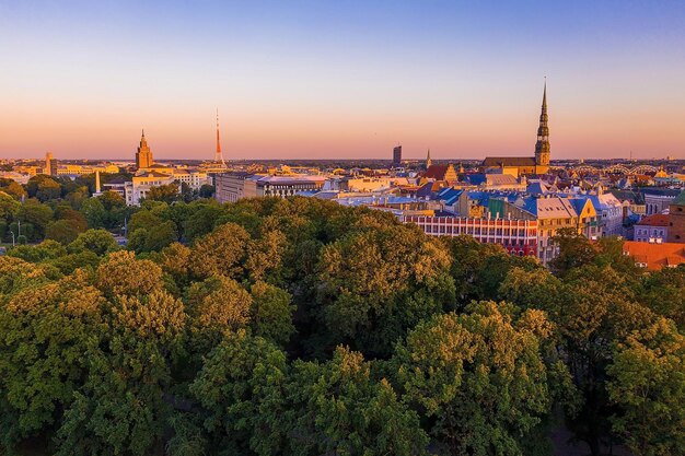 Beautiful aerial panorama of Riga center and Vansu bridge over Daugava river during amazing sunset. View of illuminated Riga city, capital of Latvia.