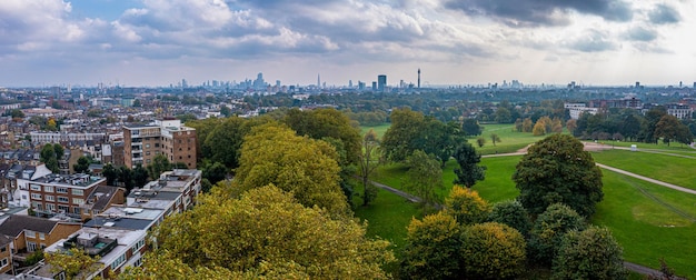 Beautiful aerial view of London with many green parks and city skyscrapers in the foreground