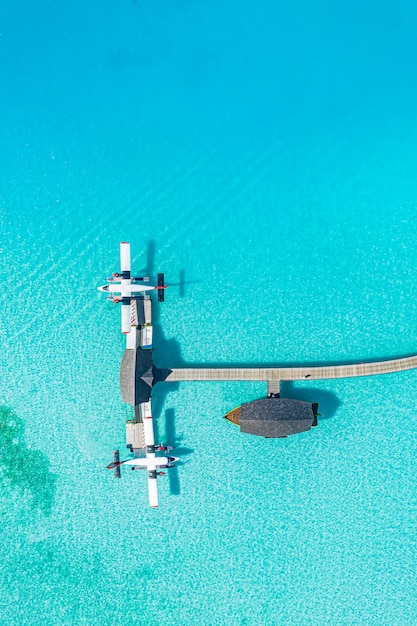 Beautiful aerial view of Maldives jetty seaplane top view with wooden boat Dhoni and tropical beach,