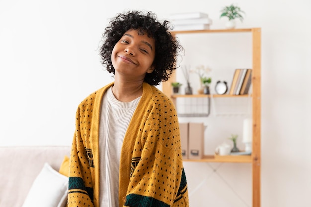 Beautiful african american girl with afro hairstyle smiling at home indoor young african woman with