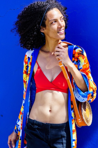 Красивая афро-американская девушка с моделированием летней одежды на синем фоне