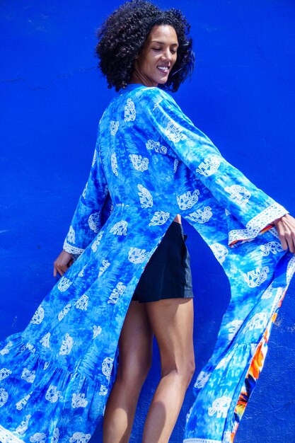 Beautiful african american girl with summer clothes modeling in blue background