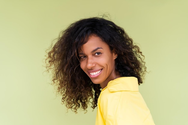 Beautiful african american woman in casual shirt on green background positive smiling laughing enjoying execited