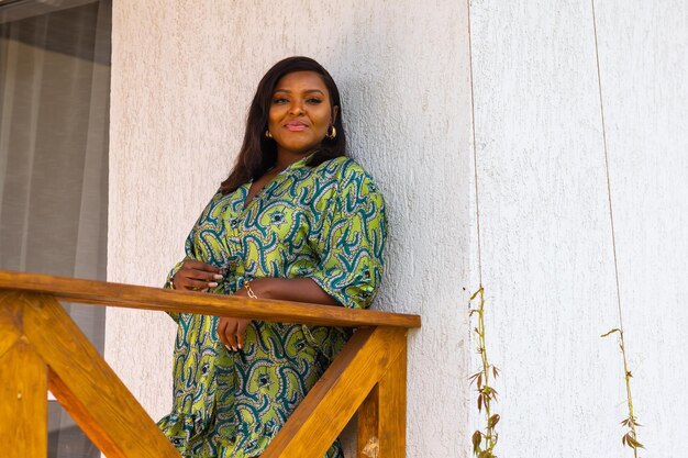 Beautiful african american woman enjoying evening on village and nature on terrace of country house Diversity and inclusion and cottagecore concept