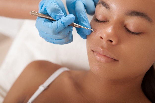 Beautiful African American woman getting a facial treatment