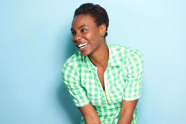 Photo beautiful african american woman laughing by blue wall