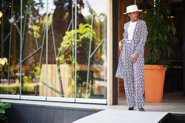 Beautiful african american woman natural makeup wear fashion clothes casual black and white dress code office style total blouse and pants suit and hat