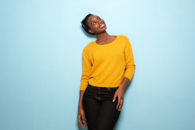 beautiful african american woman standing by blue wall