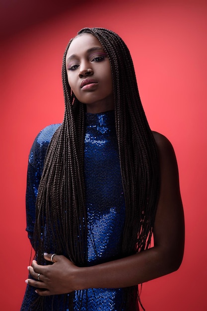 Beautiful african american woman wearing sequin party dress posing over red background