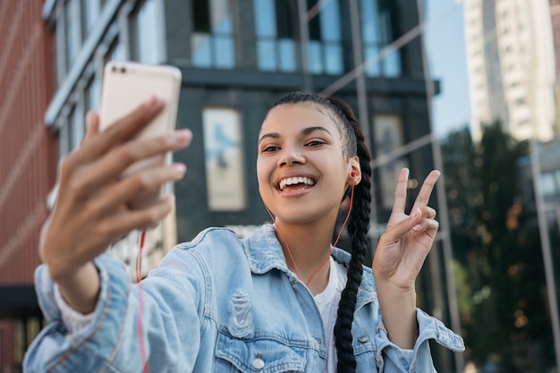 Bella donna afroamericana con l'assunzione di selfie