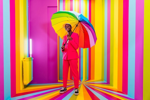 Beautiful african american young woman dancer having fun inside a rainbow box room