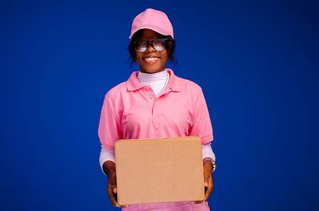 Beautiful african female courier worker holding a box