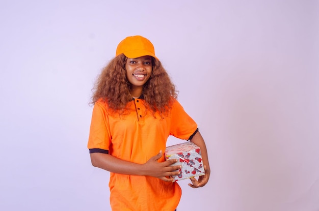 Beautiful african female courier worker holding a box