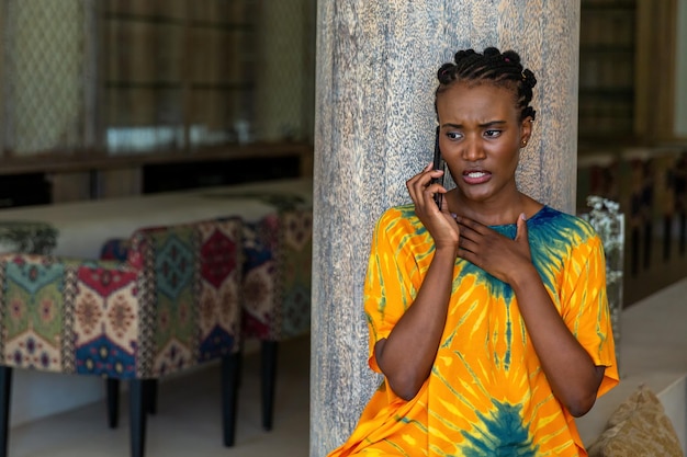 A beautiful, African girl is talking on the phone.
