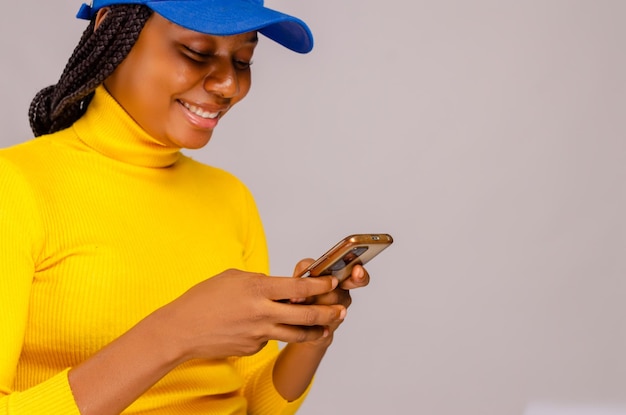 Beautiful african lady feeling excited as she operates her cellphone