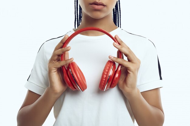 Beautiful african teenage girl with dreadlocks in sportswear listening music