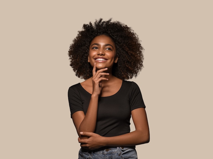 Photo beautiful african woman black t-shirt portrait afro haircut touching her face color background brown