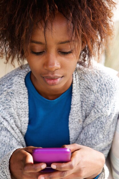 Beautiful african woman holding mobile phone