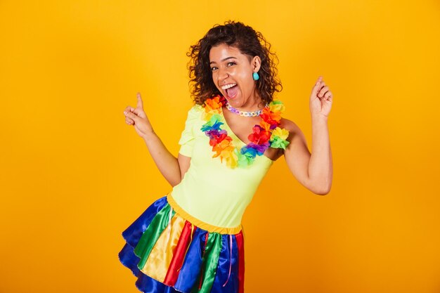 Beautiful afro american brazilian girl in carnival clothes dancing with flower necklace