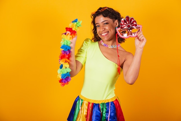 Beautiful afro american brazilian girl in carnival clothes wearing flower necklace and and carnival mask