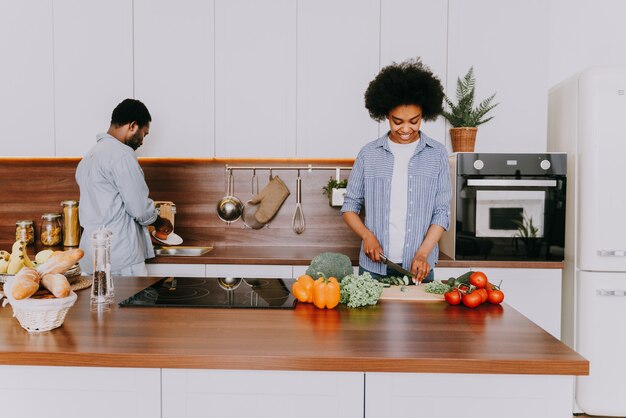 Bella coppia afroamericana che cucina a casa - bella e allegra coppia nera che prepara la cena insieme in cucina