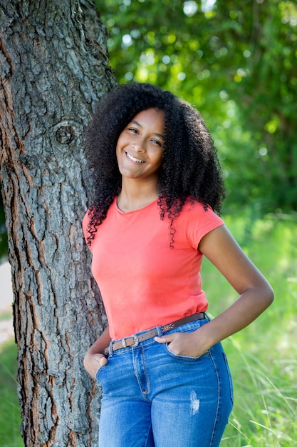 Beautiful afro teenager girl by a tree