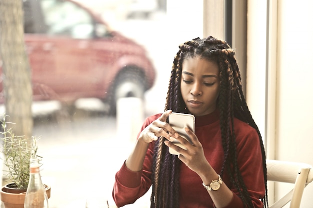 Beautiful Afro woman checking her smartphone