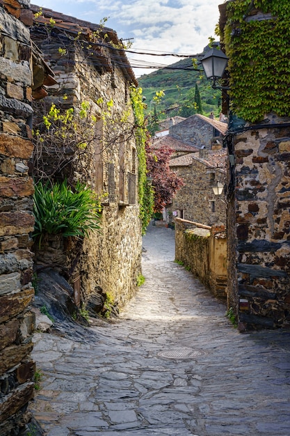 Beautiful alley of stone houses with morning light entering between the buildings. Patones de Arriba Madrid