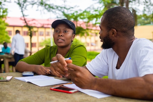 Foto bella studentessa afroamericana che si sente eccitata mentre studia il suo progetto.