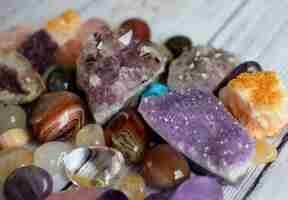 Photo beautiful amethyst crystals round rose quartz stone and bostwana agate on a wooden background magic amulets