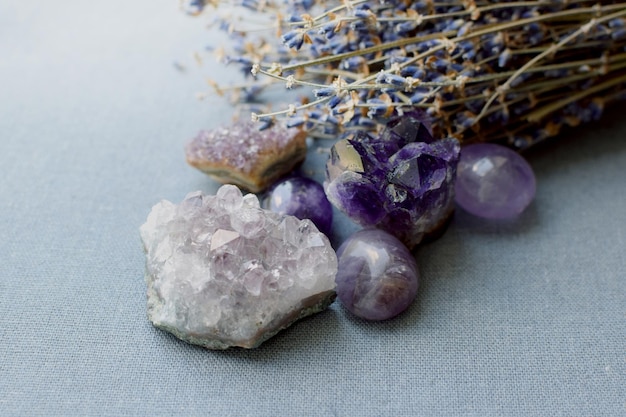 Beautiful amethyst stones and amethyst druze with dry lavender bouquet on cotton fabric Magic amulets