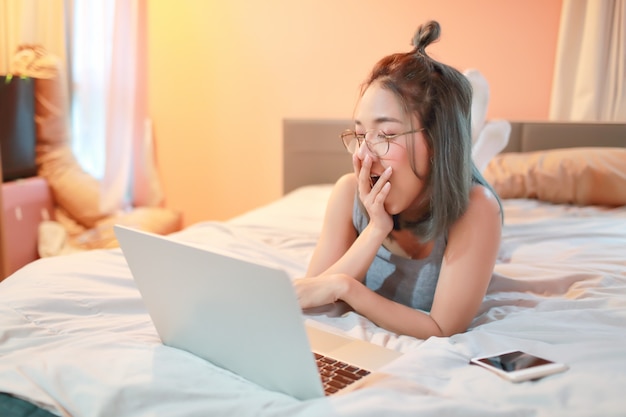 Красивая и сексуальная женщина, используя портативный компьютер перед сном