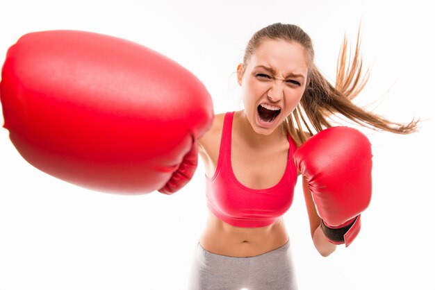 Beautiful angry sportswoman in red boxing gloves