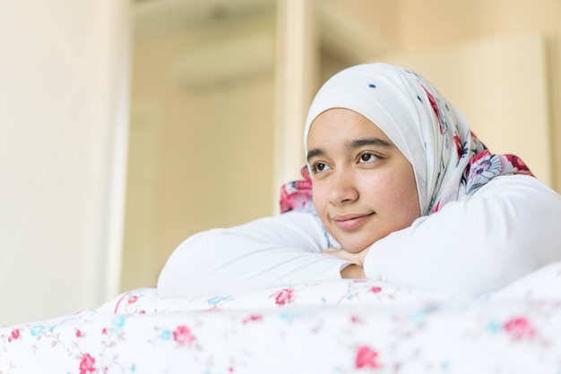 현대 침실에서 침대에 아름다운 아랍어 소녀
