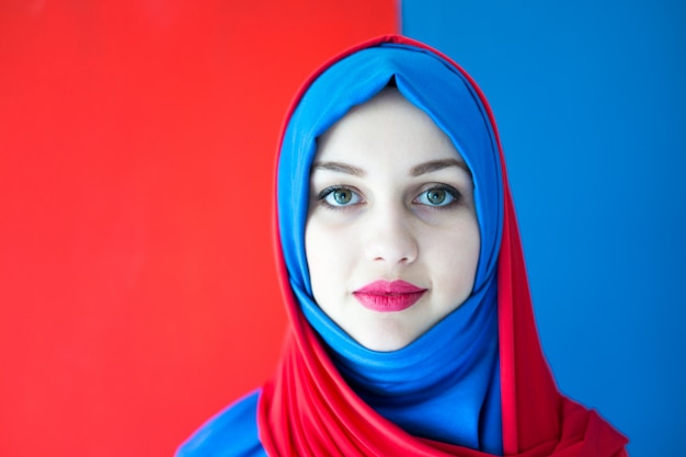 Beautiful Arabic girl with scarf over blue background