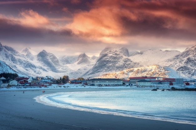 Beautiful arctic sandy beach with blue sea in winter at sunset