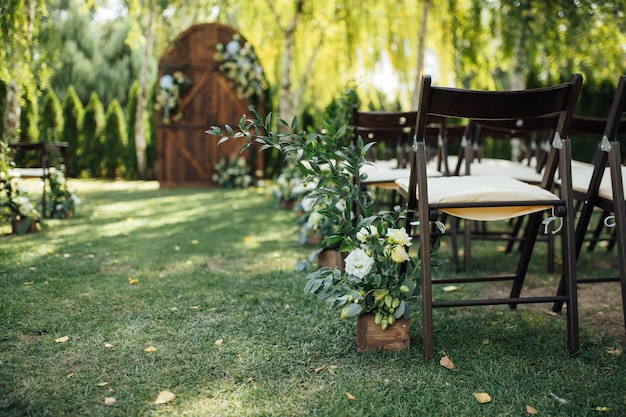 A beautiful area for an outdoor wedding ceremony Arch Decorated with a large wooden door with many flowers