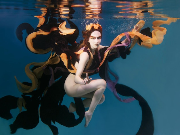 beautiful artistic young woman in dress dancing underwater. Mermaid, harvest, dance, fairy concept