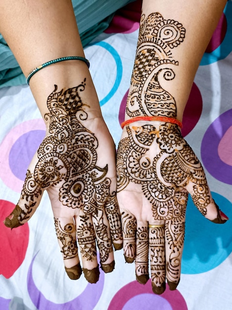 Photo beautiful artwork drawn on the hand of an indian bride with herbal heena in wet condition