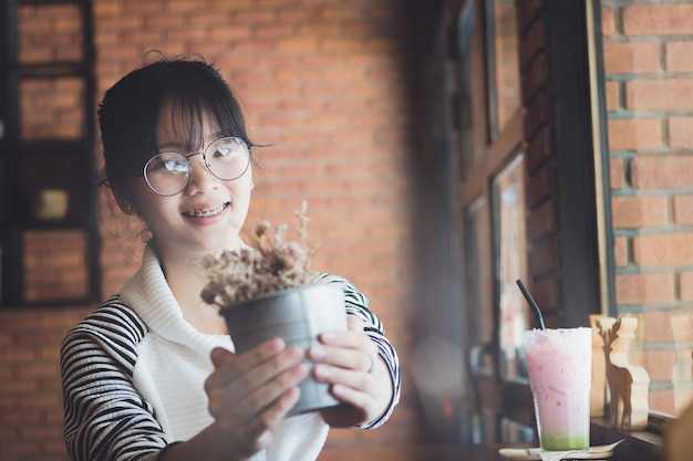 누군가에게 항아리에 꽃을주는 아름다운 아시아 여자