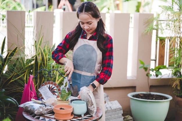 写真 庭の木の鍋に美しいアジアの女性の植物