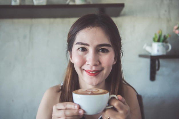 Beautiful asia woman smell coffee in a coffee shopthailand peopleCoffee timeHappy woman smile